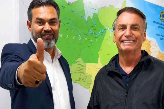 Bruno Scheid e Jair Bolsonaro em campanha O candidato Bruno Scheid e o ex-presidente Jair Bolsonaro posam juntos para fotografia, estando um mapa do Brasil em pano de fundo.