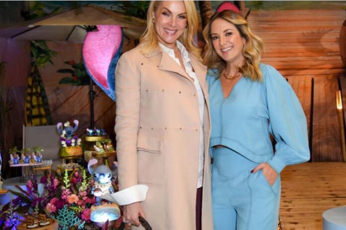 Ana Hickmann e Ticiane Pinheiro juntas As apresentadoras Ana Hickmann e Ticiane Pinheiro sorridentes durante um evento social.