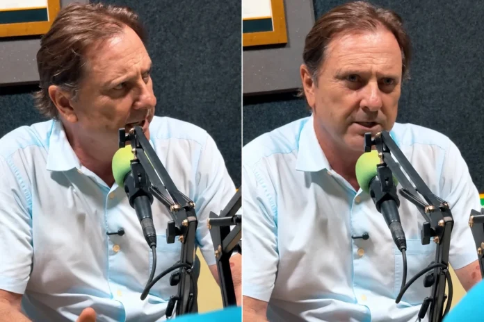 O candidato Acir Gurgacz, vestindo uma camisa social clara, fala ao microfone durante uma entrevista em um estúdio de rádio ou podcast.