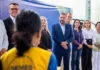 Hildon quer levar modelo de alfabetização de PVH ao estado O candidato Hildon Chaves, vestindo terno azul, sorri enquanto está rodeado por profissionais da educação e autoridades durante um evento em uma quadra escolar.