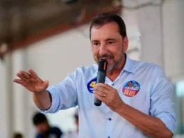 O candidato Hildon Chaves, a discursar num evento de campanha, envergando uma camisa com um autocolante eleitoral.