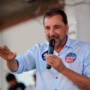 Hildon Chaves promete hospital de urgência para Rondônia O candidato Hildon Chaves, a discursar num evento de campanha, envergando uma camisa com um autocolante eleitoral.