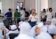 A deputada estadual Ieda Chaves discursa ao microfone para trabalhadores durante visita a uma empresa do interior de Rondônia.