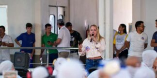 A deputada estadual Ieda Chaves discursa ao microfone para trabalhadores durante visita a uma empresa do interior de Rondônia.