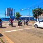 Acidentes com motos ampliam demanda do SAMU em PVH Trânsito em Porto Velho, mostrando vários motociclistas e um carro branco parados aguardando o semáforo abrir em um dia ensolarado.