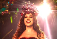 Anitta coroada rainha de bateria da Grande Rio A cantora Anitta sorridente e iluminada, a usar uma coroa vermelha cravejada de pedras e búzios durante o evento da Grande Rio.