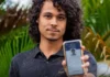 Prazo para baixar o e-Título termina no dia 3 de outubro Um jovem de cabelos cacheados sorri levemente enquanto exibe, em primeiro plano, a tela do seu celular com o aplicativo do e-Título aberto e validado.