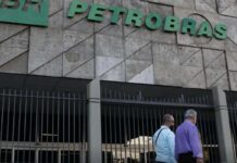 Petrobras aprova adesão à subvenção para o óleo diesel Fachada do edifício sede da Petrobras com portões metálicos e pessoas a caminhar na entrada.