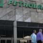 Petrobras aprova adesão à subvenção para o óleo diesel Fachada do edifício sede da Petrobras com portões metálicos e pessoas a caminhar na entrada.