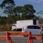 TJRO trava recurso da Nova 364 sobre buraco em rodovia Funcionário com colete da Nova 364 a sinalizar a rodovia junto a barreiras de segurança e veículos em trânsito.