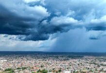 Nuvens densas e escuras a cobrir uma área urbana da Região Norte, indicando a aproximação de precipitação isolada.