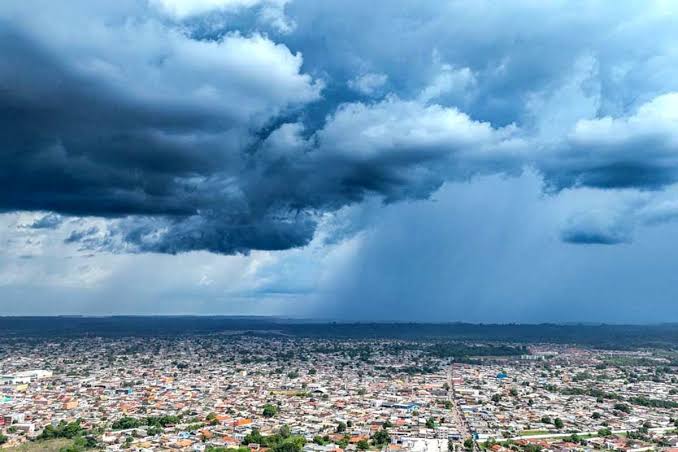 Formacao de nuvens de chuva em cidade da Regiao Norte Nuvens densas e escuras a cobrir uma área urbana da Região Norte, indicando a aproximação de precipitação isolada.