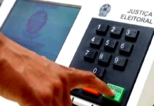 Aposentados e pensionistas que votarem ficam isentos de realizar a Prova de Vida Dedo de um eleitor a pressionar a tecla verde de confirmação numa urna eletrónica da Justiça Eleitoral.