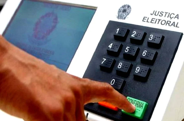 Aposentados e pensionistas que votarem ficam isentos de realizar a Prova de Vida Dedo de um eleitor a pressionar a tecla verde de confirmação numa urna eletrónica da Justiça Eleitoral.