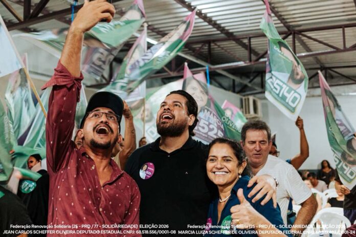 Os candidatos Jean Oliveira e Márcia Oliveira sorriem e celebram com apoiadores durante uma grande reunião política em Porto Velho.