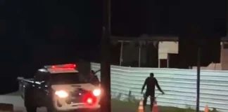 Homem é morto com pedaço de concreto em Santa Luzia Viatura da Polícia Militar com o giroflex ligado isolando o local de um crime em uma rua durante a noite, com cones de sinalização na pista e um policial ao fundo.