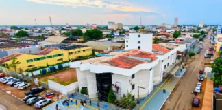Novo Hospital Municipal fará 19 mil procedimentos ao ano Fotografia aérea mostrando a fachada e a infraestrutura do novo Hospital Municipal de Porto Velho, um prédio amplo e pintado de branco, com movimentação na rua ao redor.