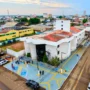 Novo Hospital Municipal fará 19 mil procedimentos ao ano Fotografia aérea mostrando a fachada e a infraestrutura do novo Hospital Municipal de Porto Velho, um prédio amplo e pintado de branco, com movimentação na rua ao redor.