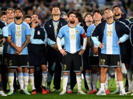 Propaganda com drones em despedida de Messi gera revolta O jogador Lionel Messi em pé no gramado do estádio, olhando para o alto com uma expressão de claro desconforto e frustração.