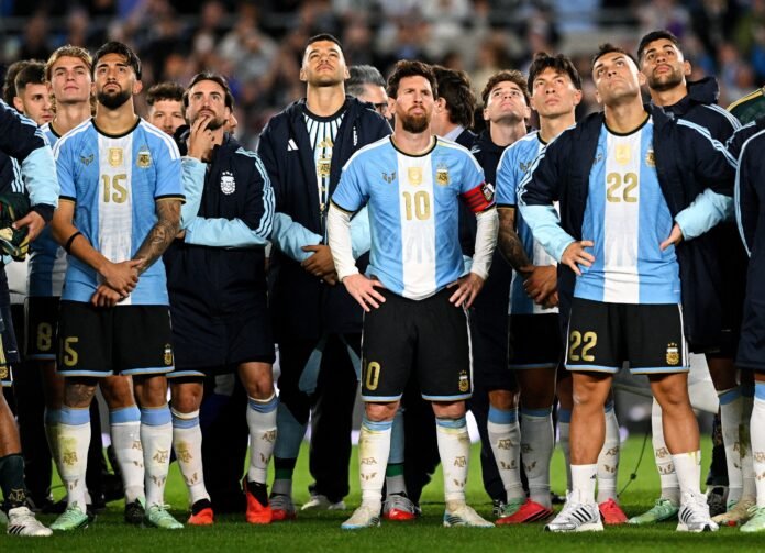 Messi observa show de drones em sua despedida da seleção argentina O jogador Lionel Messi em pé no gramado do estádio, olhando para o alto com uma expressão de claro desconforto e frustração.