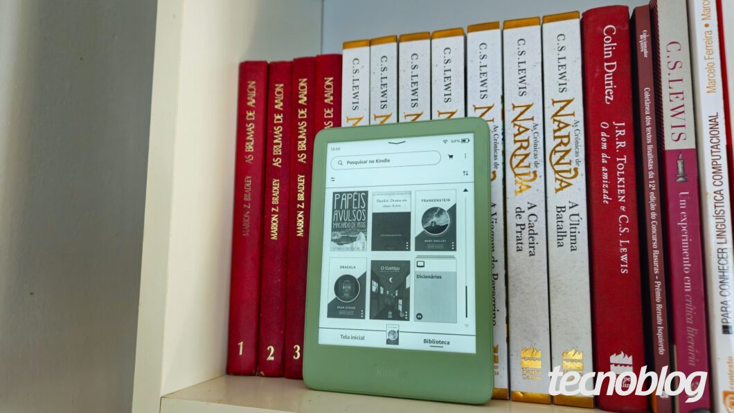 Kindle exibindo a biblioteca, com livros atrás