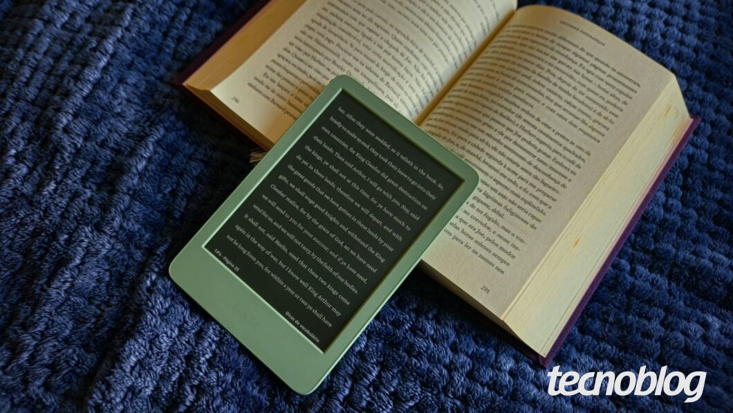 Kindle repousado sobre um livro aberto
