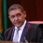 TSE determina suspensão de canal de André Janones no WhatsApp a pedido de Flávio Bolsonaro O ministro Kassio Nunes Marques, presidente do TSE, vestindo toga preta e gravata azul, segurando uma caneta durante uma sessão no tribunal.