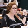 A ex-deputada federal Carla Zambelli, vestindo trajes formais, falando ao microfone durante uma sessão parlamentar.