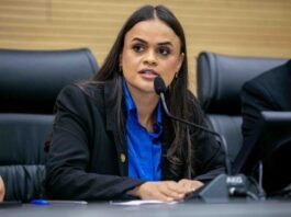 Dra. Taíssa Sousa propõe alargamento do programa Prato Fácil em Guajará-Mirim A deputada estadual Dra. Taíssa Sousa a discursar ao microfone durante uma sessão parlamentar, envergando um casaco escuro e uma camisa azul.