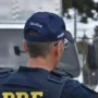 Feriado de Nossa Senhora Aparecida regista 68 mortes nas estradas Agente da Polícia Rodoviária Federal de costas, a sinalizar com a mão para orientar o trânsito rodoviário.