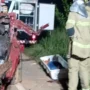 Motorista morre após bater de frente com ônibus na BR-319 em Porto Velho Bombeiros trabalham à noite ao lado de um carro vermelho totalmente destruído após um acidente. No chão está uma maca de transporte para a vítima.