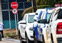 Viaturas da Polícia Militar e da Polícia Civil estacionadas em fila ao longo de uma rua durante o atendimento de uma ocorrência.