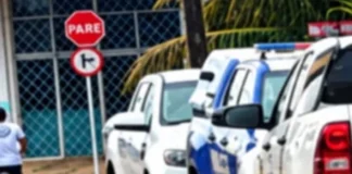 Viaturas da Polícia Militar e da Polícia Civil estacionadas em fila ao longo de uma rua durante o atendimento de uma ocorrência.