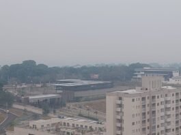 Fumaça densa atrasa sobrevoo de comitiva do governo federal no Amazonas Vista aérea de Manaus sob um céu cinzento e totalmente encoberto por uma densa camada de fumaça, dificultando a visibilidade dos prédios e da vegetação.