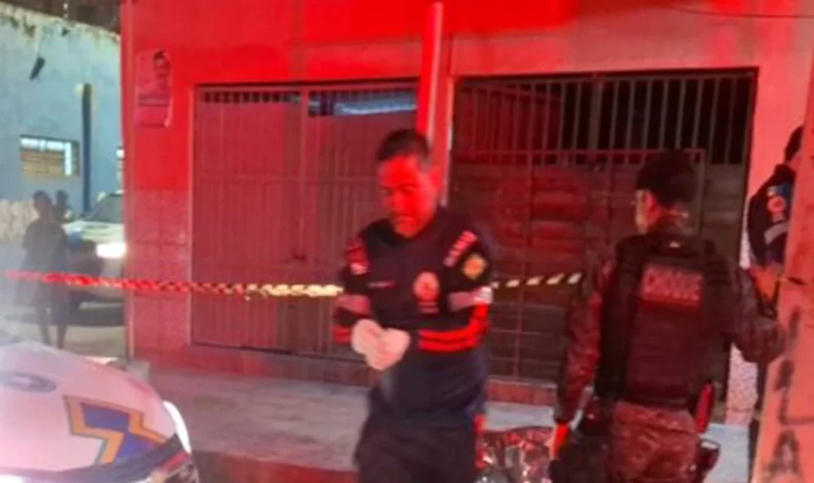 Profissional do Samu de luvas brancas e policial militar do batalhão de Choque trabalhando em uma cena de crime à noite, com área isolada por fita zebrada.