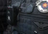 Três suspeitos morrem em tiroteio com a Polícia Militar durante assalto em São Paulo Colete tático escuro de um agente da Polícia Militar de São Paulo, equipado com uma câmara corporal (bodycam) e ostentando as insígnias oficiais da corporação.